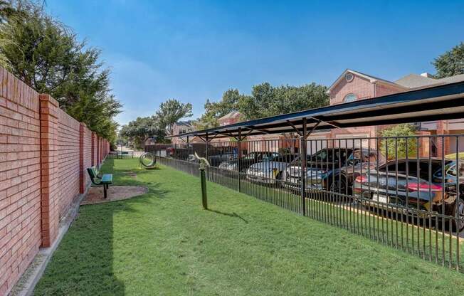 a fenced in yard with cars parked behind a fence