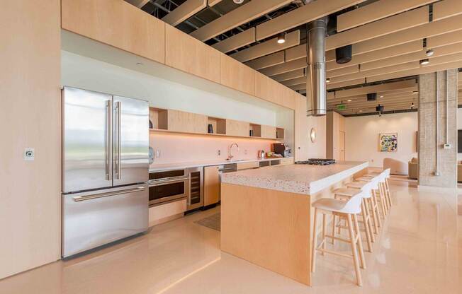 A modern kitchen with a long counter and stainless steel appliances at Allied Harbor Point, Baltimore