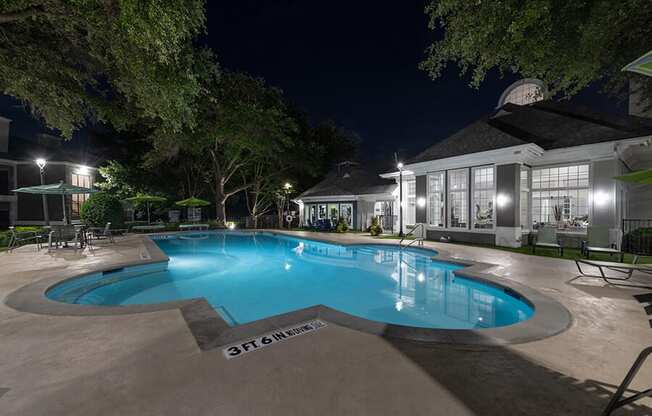 Community Swimming Pool with Pool Furniture at Bridges at Oakbend Apartments located in Lewisville, TX.