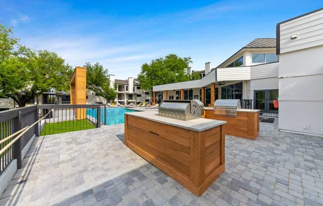 a backyard patio with a grill and a swimming pool