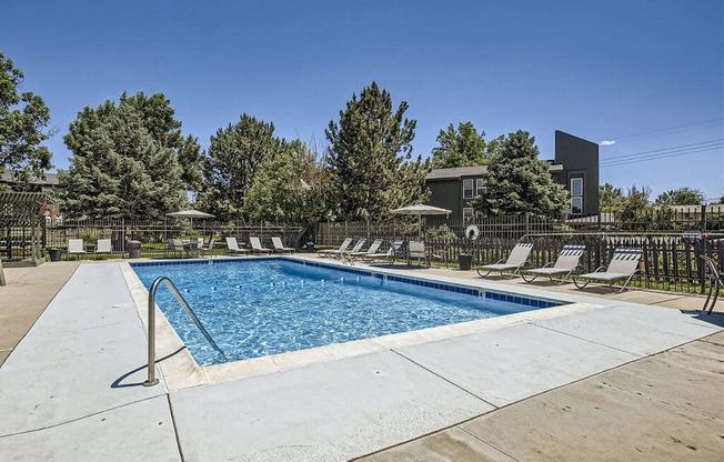 the pool is heated and has lounge chairs around it