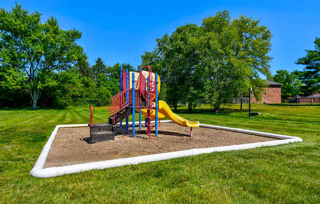 Playground at Ashton Brook Apartments, featuring slides and a colorful play structure.