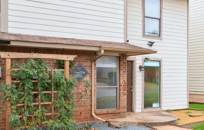 the front porch of a house with a brick wall and a door at Diamond Ridge Townhomes, Oklahoma City