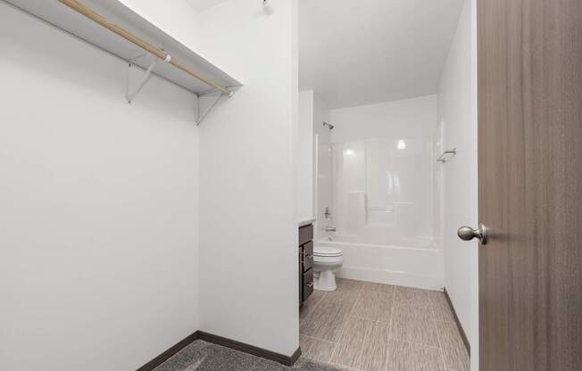 A white bathroom with a toilet, sink, and mirror.