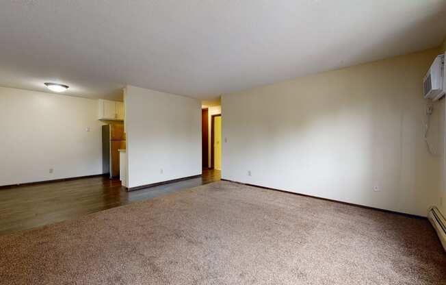 an empty living room with white walls and a beige carpet