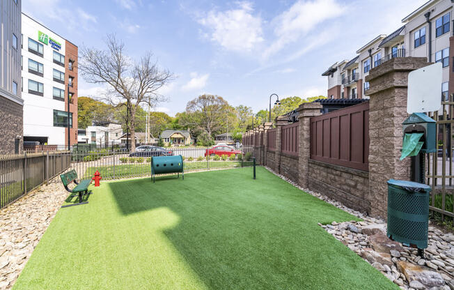a backyard with a green lawn and a fire hydrant   and a fence