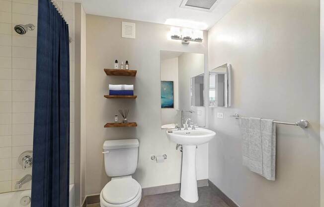 a bathroom with a toilet sink and mirror and a shower