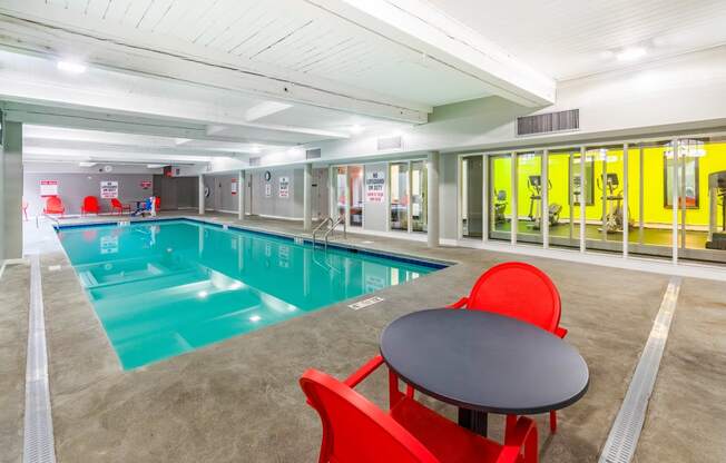 a swimming pool with a table and chairs next to it at Royal Worcester Apartments, Massachusetts