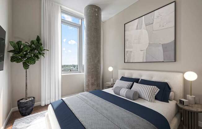 A bedroom with a large bed and a potted plant.