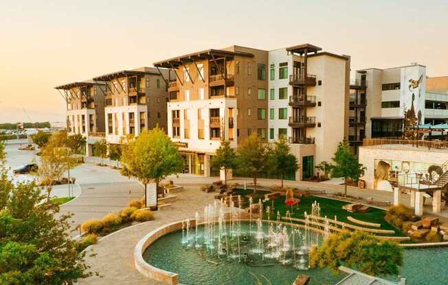 a view of a fountain in front of an apartment building