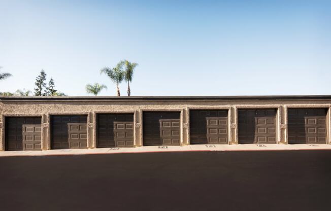 a row of garages with palm trees in the background