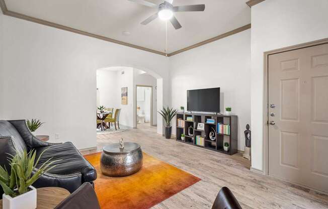 A living room with a black leather couch and a television.