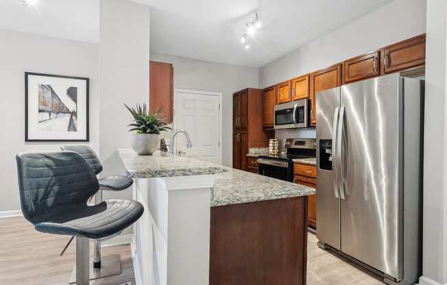 luxury kitchen with granite countertops including a bar and stainless appliances at Sorelle apartments