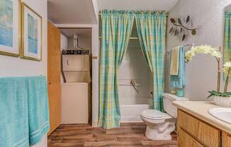 A bathroom with a toilet, sink, and shower curtain.