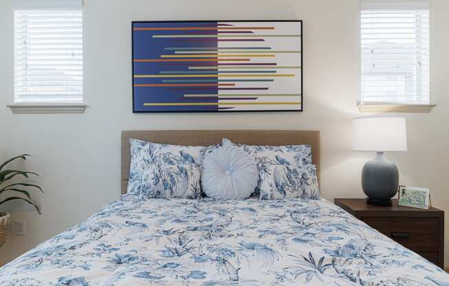 a bedroom with a bed with a blue and white comforter and pillows
