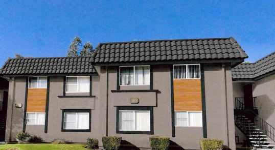 the front of a house with a blue sky in the background