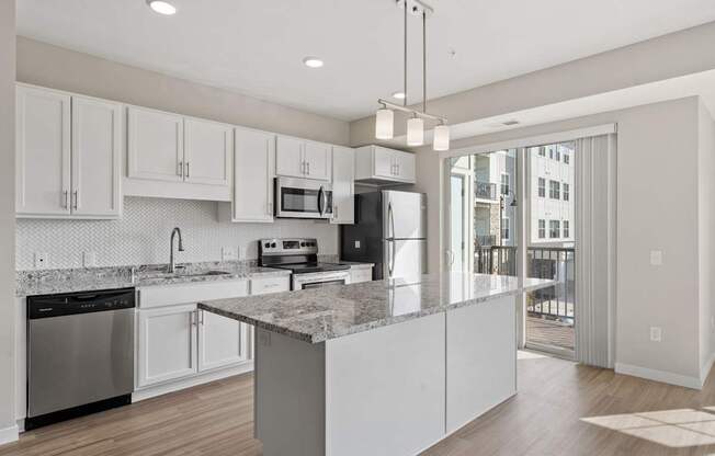 A kitchen with a granite countertop and stainless steel appliances.