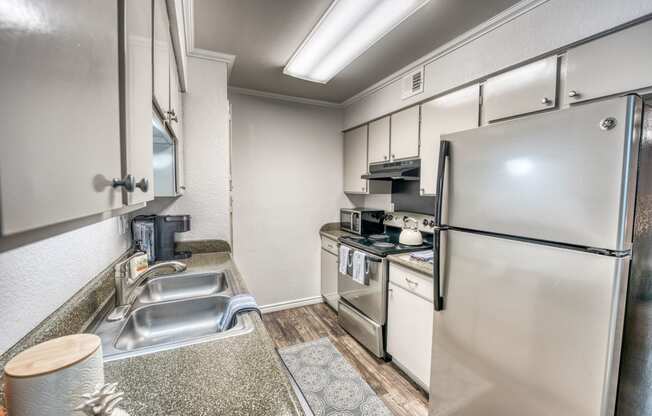 the kitchen has stainless steel appliances and white cabinets