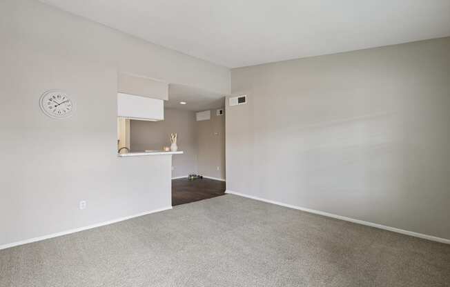 A room with a clock on the wall and a shelf with decorations.