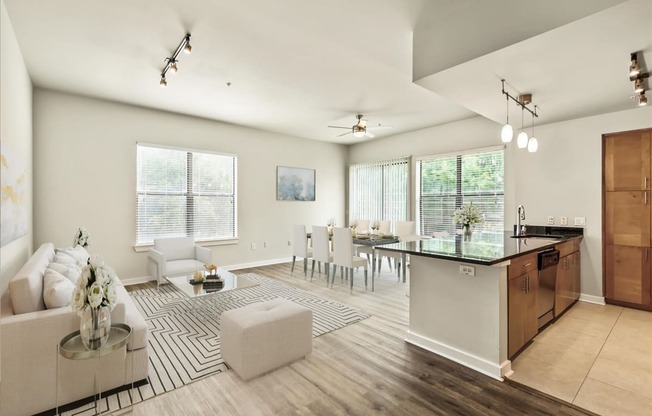 a living and dining room area with white walls and hardwood flooring