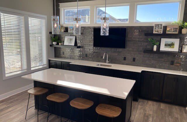 a kitchen with a white counter top and three stools