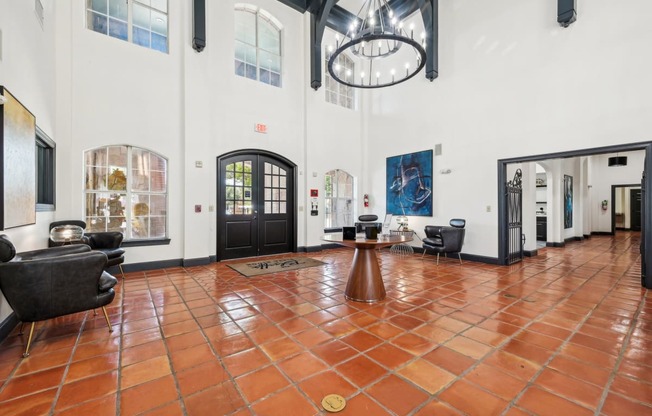 the lobby of a large white building with chairs and a table