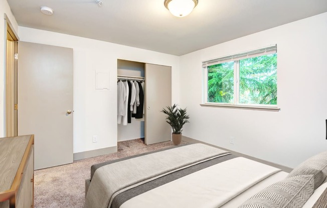 a bedroom with a bed and a window and a closet