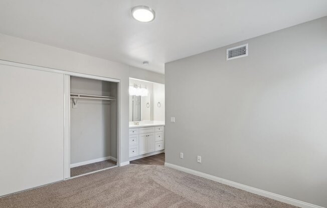 an empty bedroom with a closet and a bathroom
