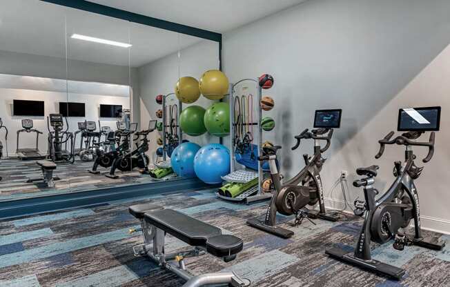a gym with exercise equipment and mirrors at Latitudes apartments