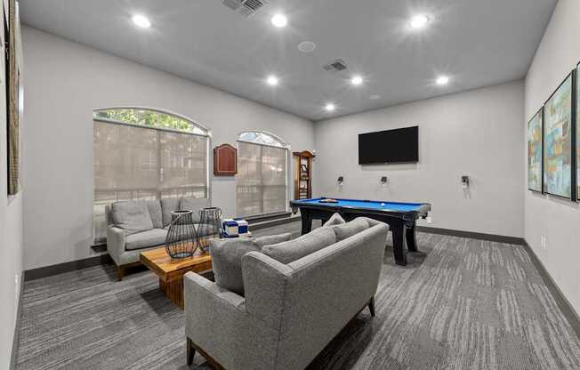 A room with a pool table and a television.