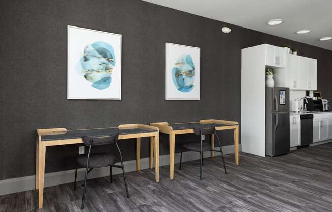 a dining room with a table and chairs and two paintings on the wall