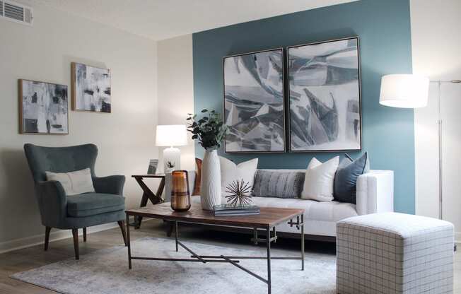 living room with hardwood-style flooring and teal accent wall and model furniture  at Huntsville Landing Apartments, Alabama, 35806