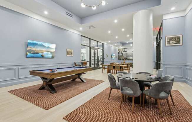 A room with a pool table and a dining table.