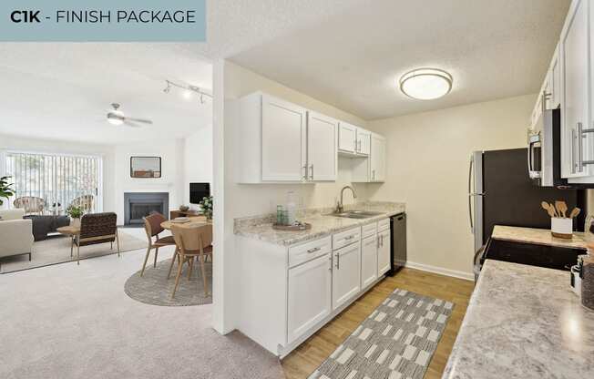 A kitchen with white cabinets and a marble countertop.
