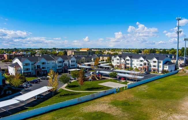 Aerial view of the Eagles Landing neighborhood with apartment buildings and a green area with a playground at Eagles Landing Apartments, Idaho