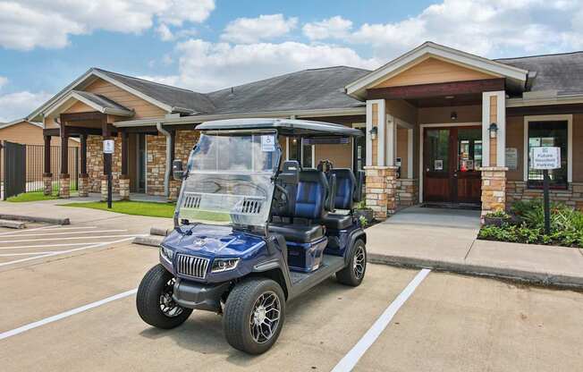 A blue golf cart is parked in front of a building with a sign on it.