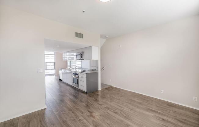 A kitchen with white walls and wooden floors.