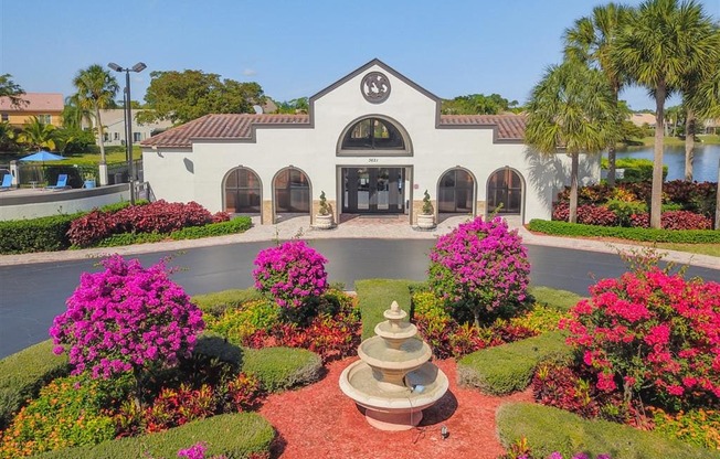 Pet-Friendly Apartments in Coconut Creek, FL – Waterview at Coconut Creek – outside leasing office with water fountain and lots of bushes with pink flowers