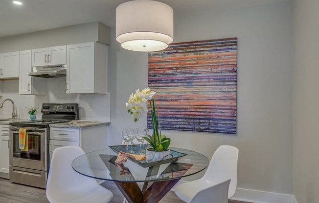 a kitchen and dining room with a glass table and chairs