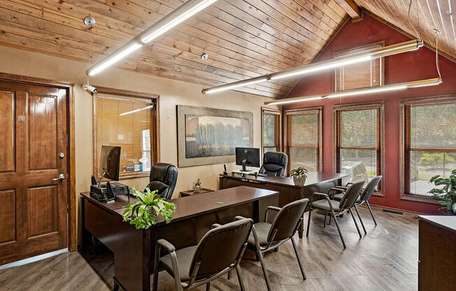 a conference room with a large desk and chairs and a computer