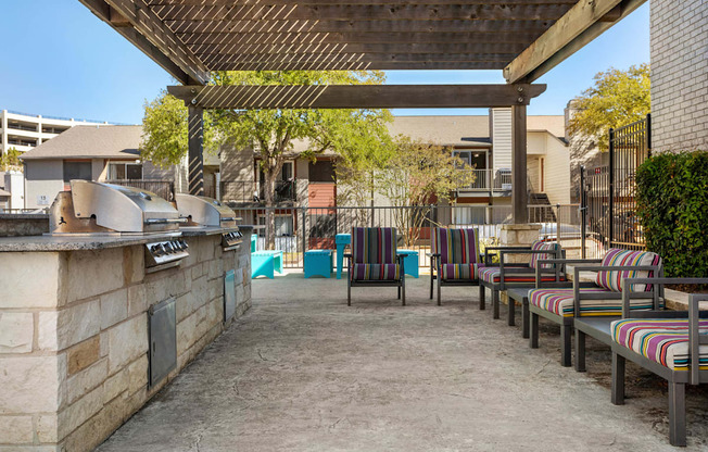 a outdoor patio with a grill and chairs at South Lamar Village, Austin, TX