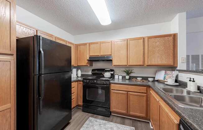 A kitchen with black appliances and wooden cabinets.