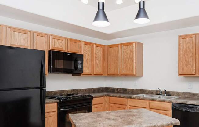 A kitchen with black appliances and wooden cabinets.