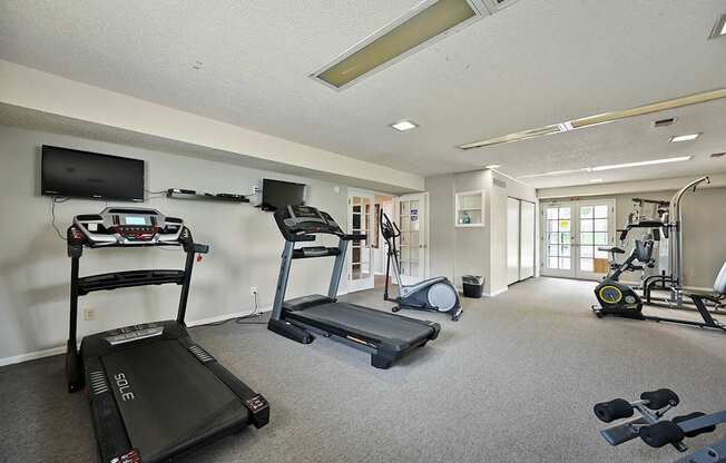 A spacious gym with treadmills, elliptical machines, and other exercise equipment.