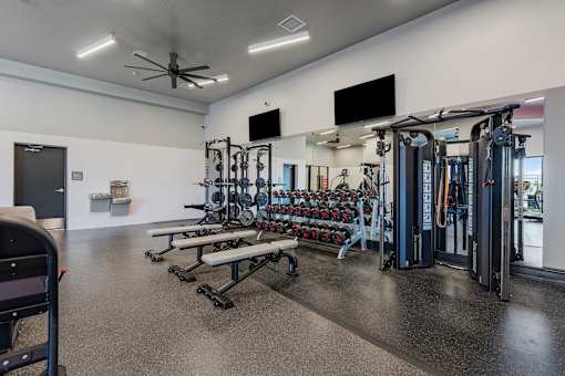 a gym with weights and cardio equipment in a building with white walls at SevenO2 Main Apartments, Utah, 84101