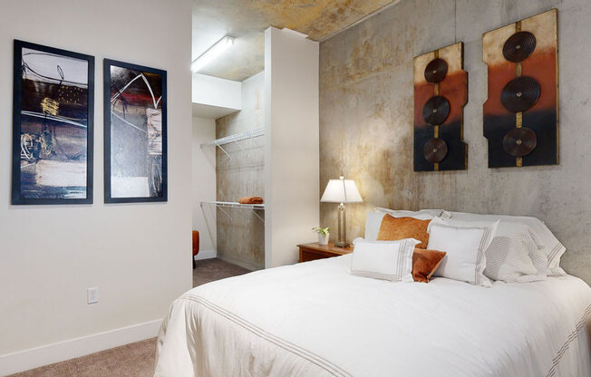 a bedroom with a bed and three paintings on the wall