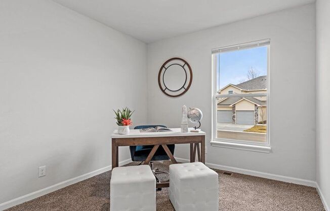 an office with a window and a table and stools