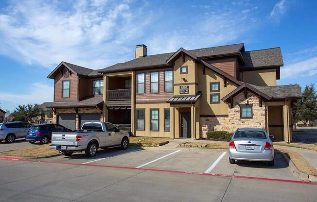 A large two-story building with a parking lot in front.