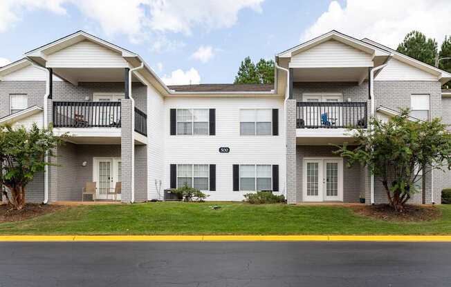 A two-story apartment building with a balcony on the second floor.