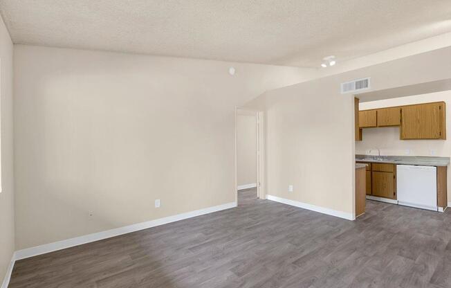 A kitchen area with a white dishwasher and wooden cabinets.